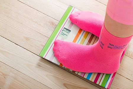 Femme en chaussette debout sur une balance