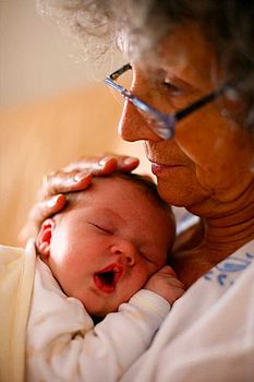 Bébé faisant une sieste dans les bras de sa grand-mère