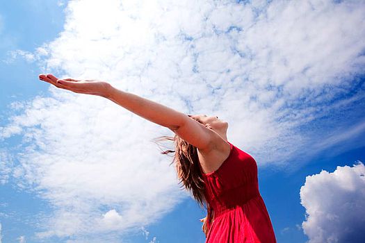 Femme enjouée tendant les bras vers le ciel