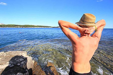Homme profitant du soleil avec sa tête protégée par un chapeau de paille
