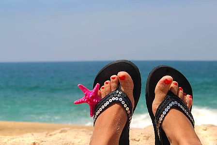 Femme exposant ses ongles de pieds sur une plage
