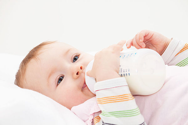 Bébé dégustant son biberon sans problème d'intolérance au lactose