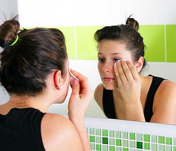 Femme se démaquillant devant son miroir