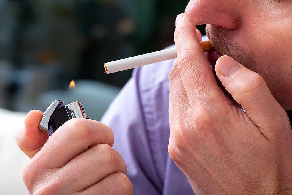 Gros plan sur un homme allumant une cigarette