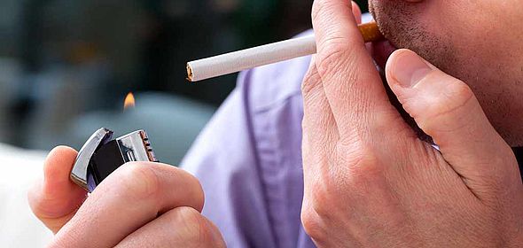 Gros plan sur un homme allumant une cigarette