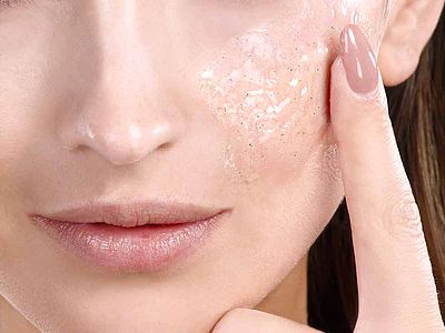 Femme se passant une crème exfoliante sur le visage