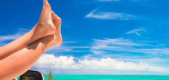 Femme profitant du soleil avec les jambes dépassant de la portière