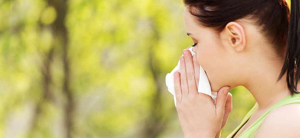 Femme se mouchant sur un fond de nature