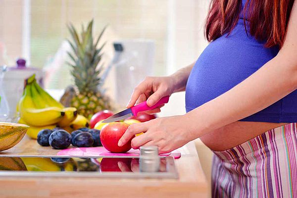 Femme enceinte préparant un repas