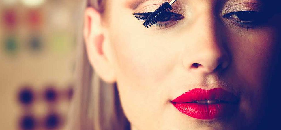 Femme avec rouge à lèvre se maquillant les yeux 