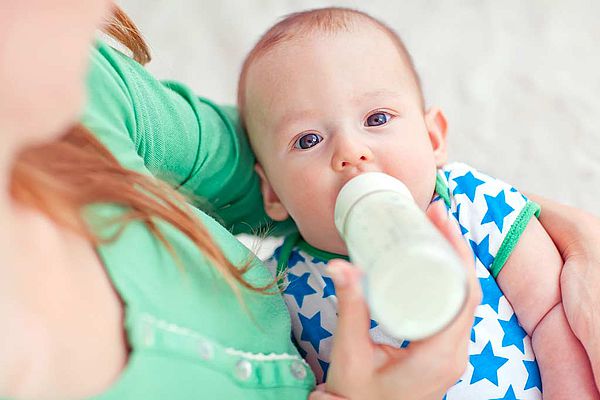 Mère donnant le biberon à son bébé