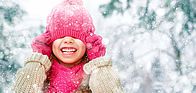 Enfant enfilant un bonnet dans un décor neigeux