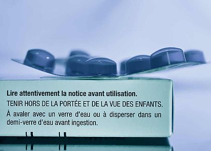 Plaquette de médicaments posée sur une boite en carton