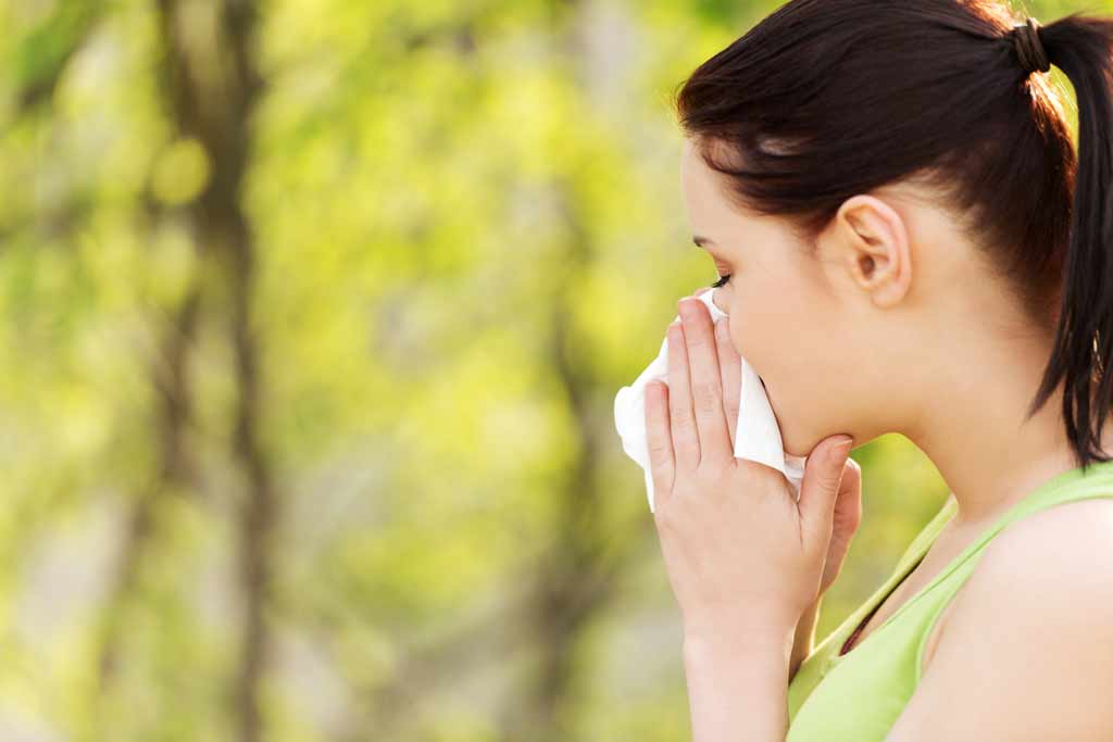 Femme se mouchant sur un fond de nature