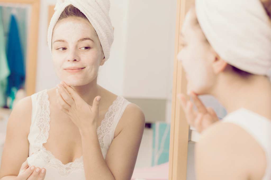 Femme se passant une crème sur le visage