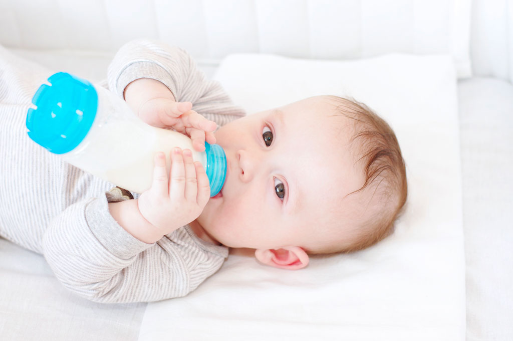 Bébé prenant son biberon de lait 2ème âge